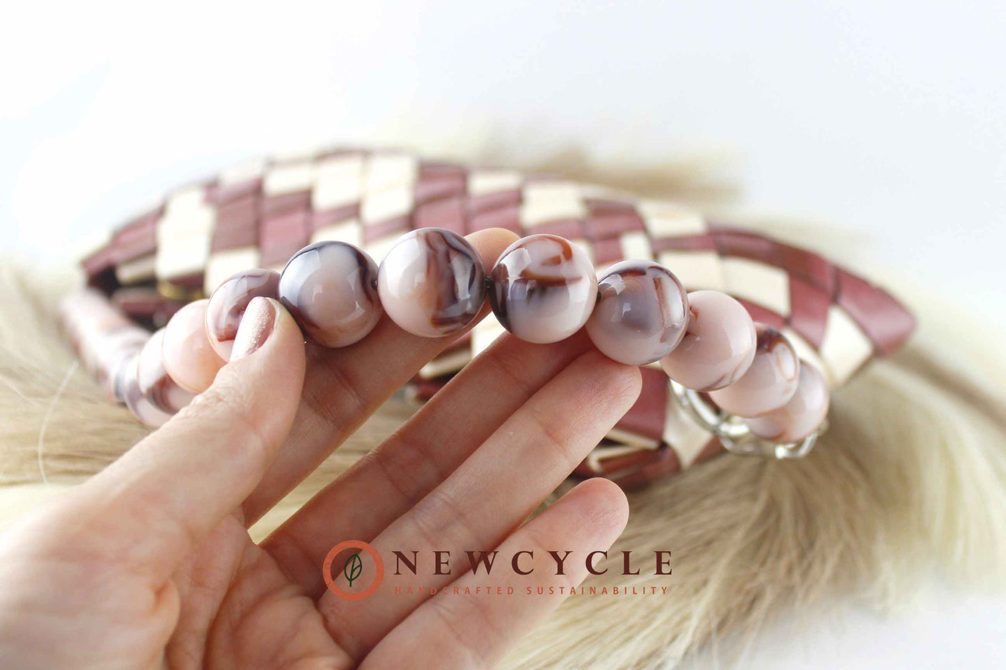 beaded handle detail on brown cream woven clutch