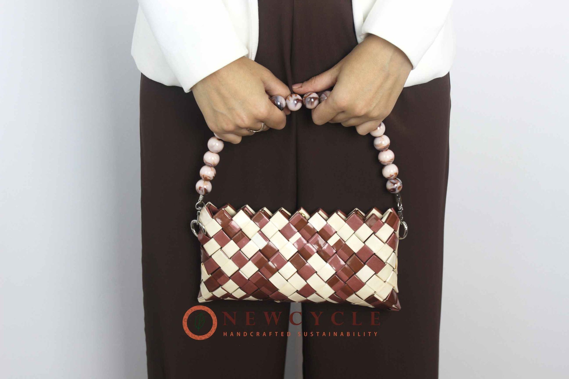 handmade brown cream clutch worn on shoulder with beaded handle