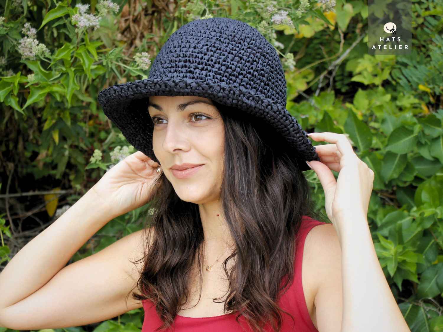Boho style black raffia hat worn by woman outdoors