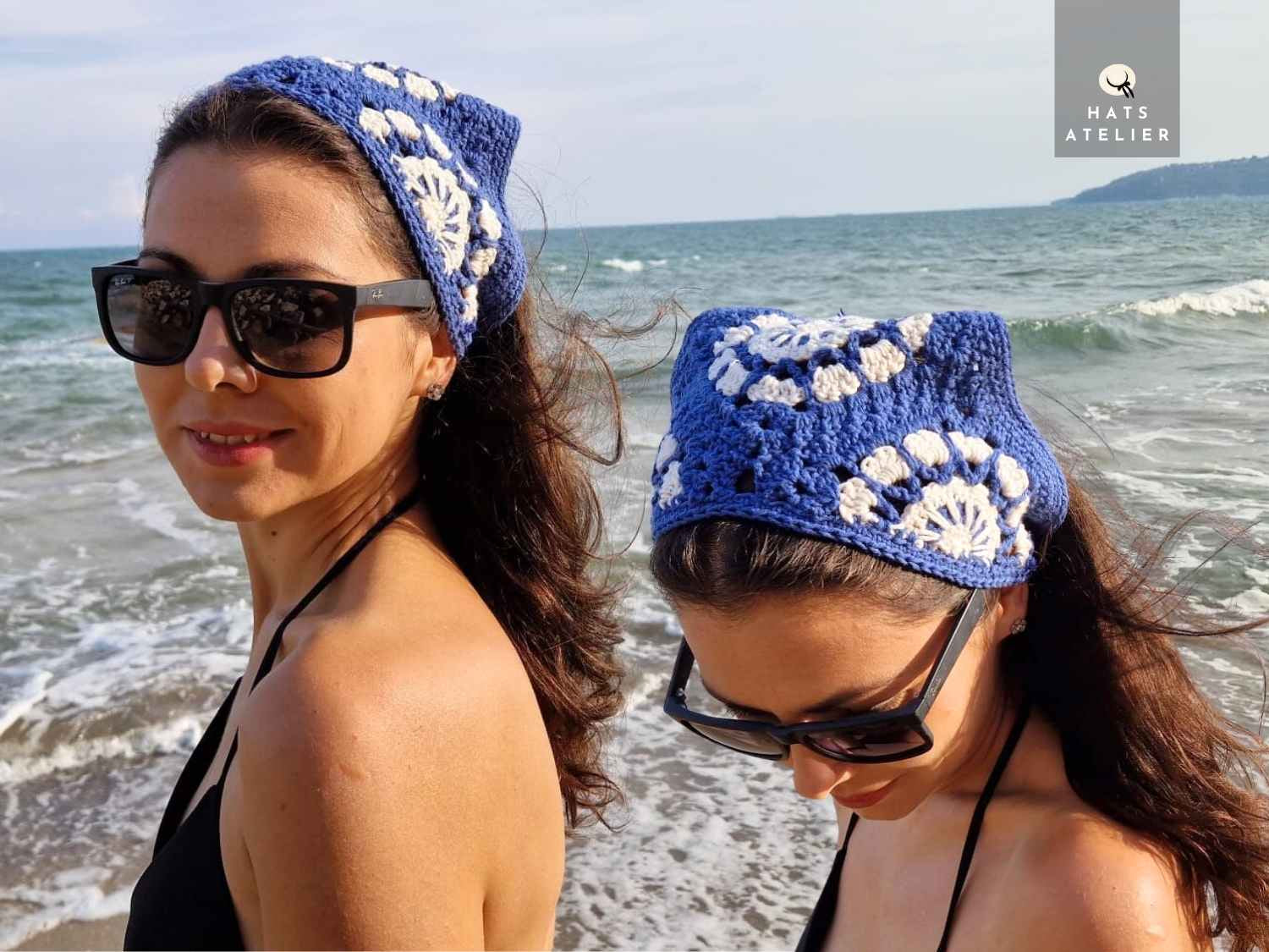 Two women wearing blue crochet hats with white patterns on a beach.