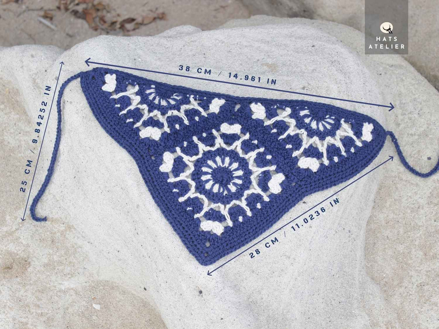 Blue and white crochet pattern on a rock with measurements and 'Hats Atelier' branding.