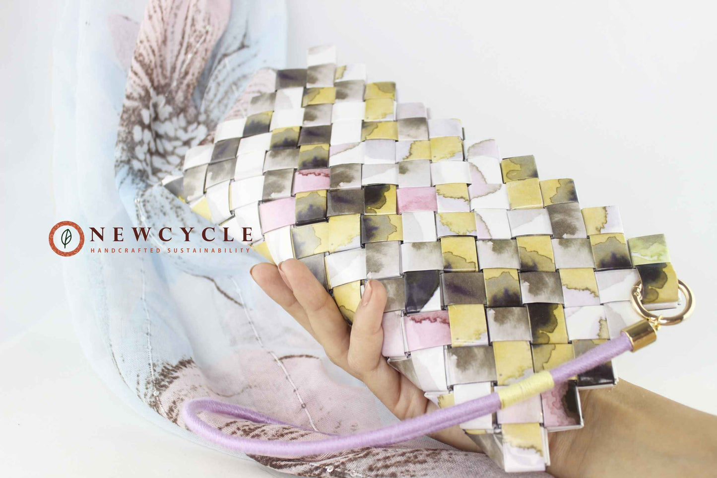 Handcrafted pastel woven clutch held in hand – eco conscious wristlet bag