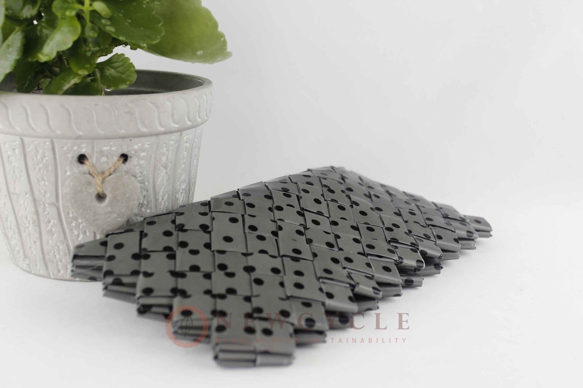 Flat lay of handmade woven clutch in grey polka dot design