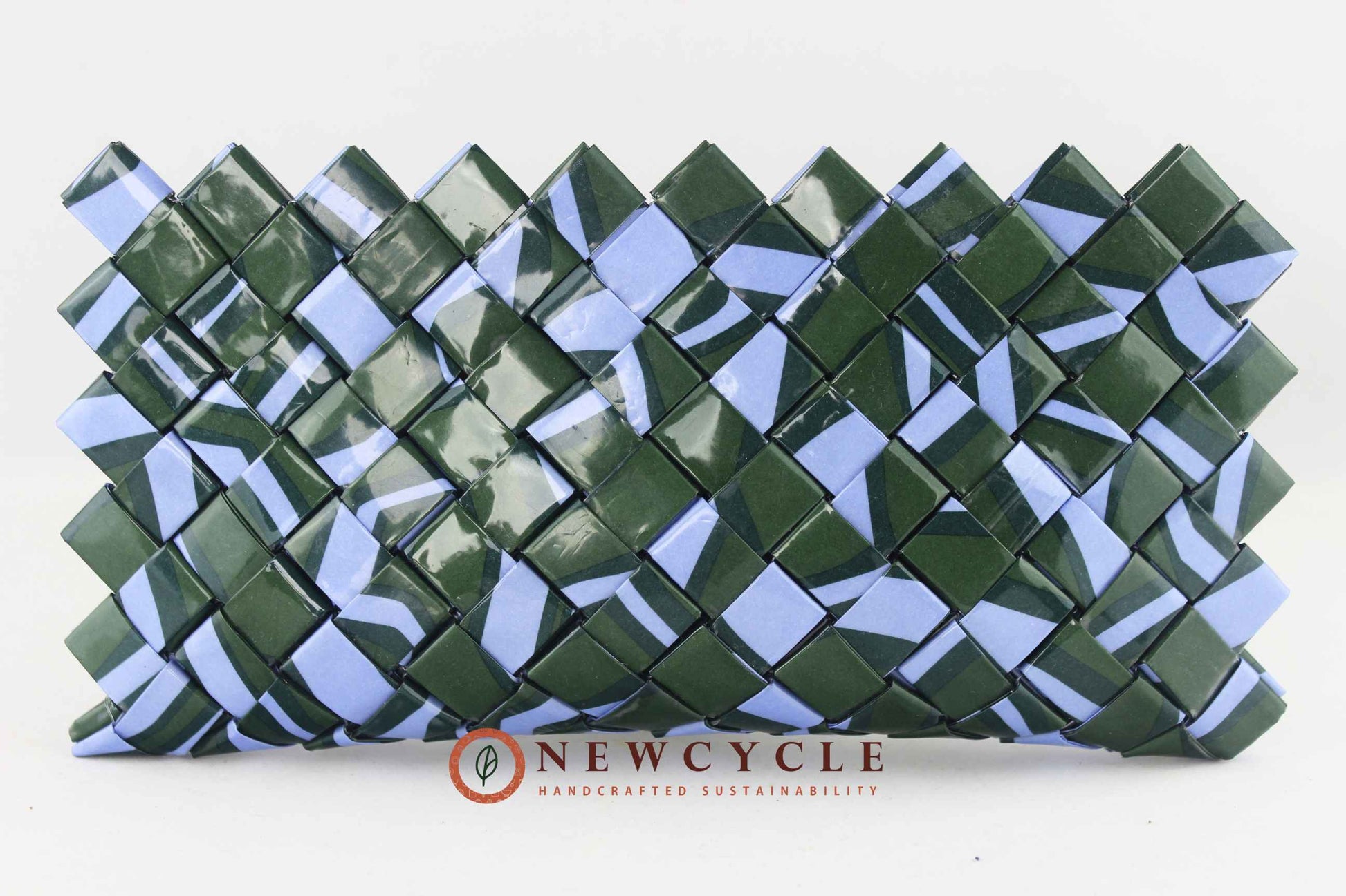 Front view of a handmade upcycled woven clutch in forest green and powder blue with the NEWCYCLE logo.