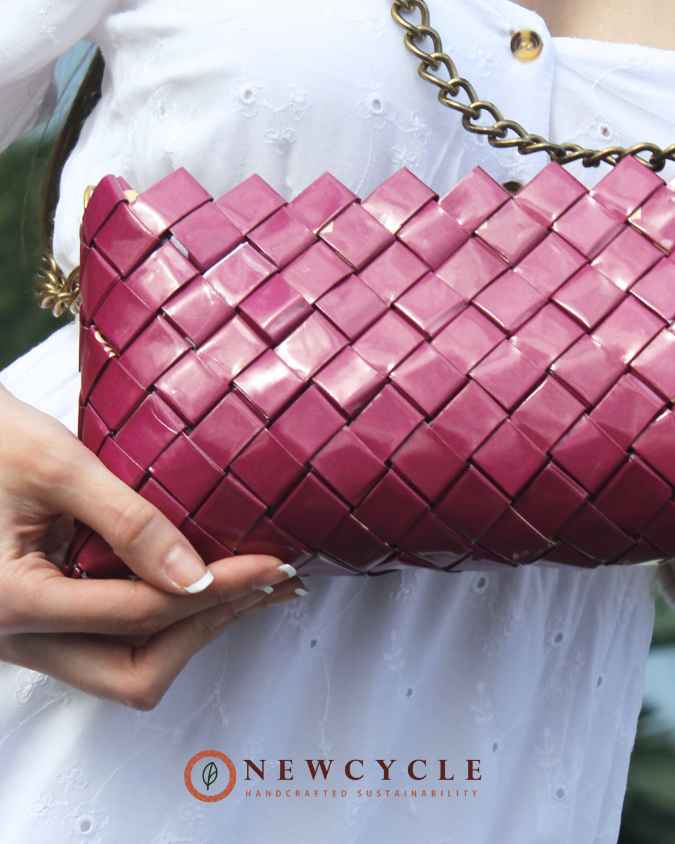 Close-up of fuchsia woven purse showing glossy handwoven pattern