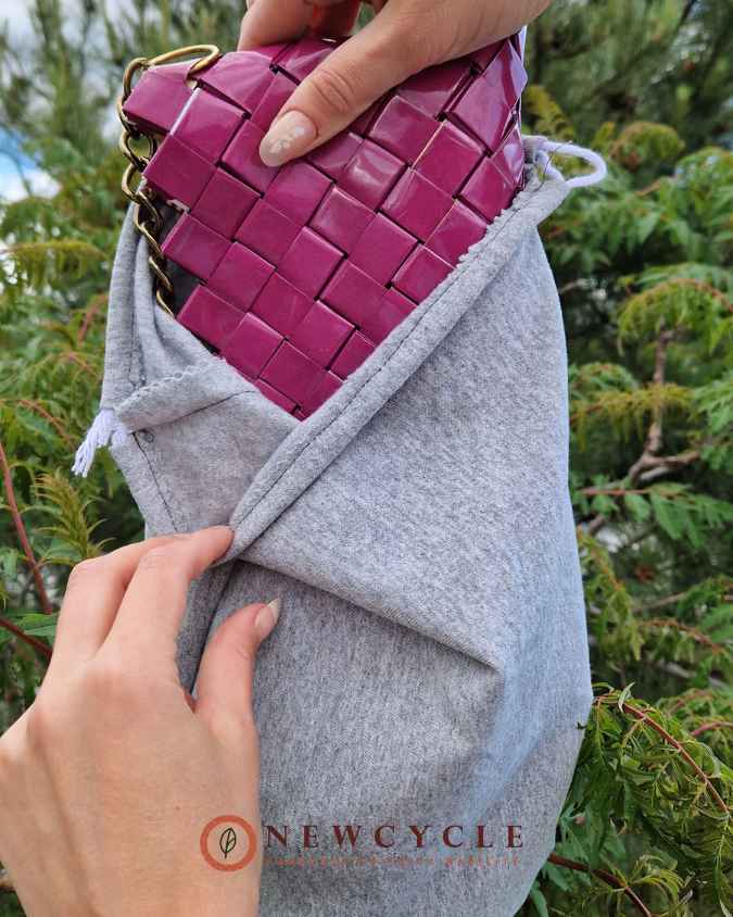 Fuchsia woven purse partially opened to show interior compartment