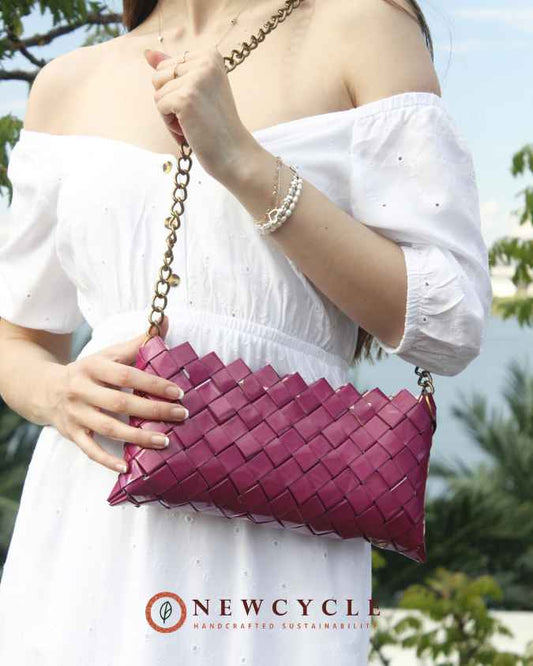 Woman holding a fuchsia woven shoulder bag with metal chain – NewCycle handmade purse