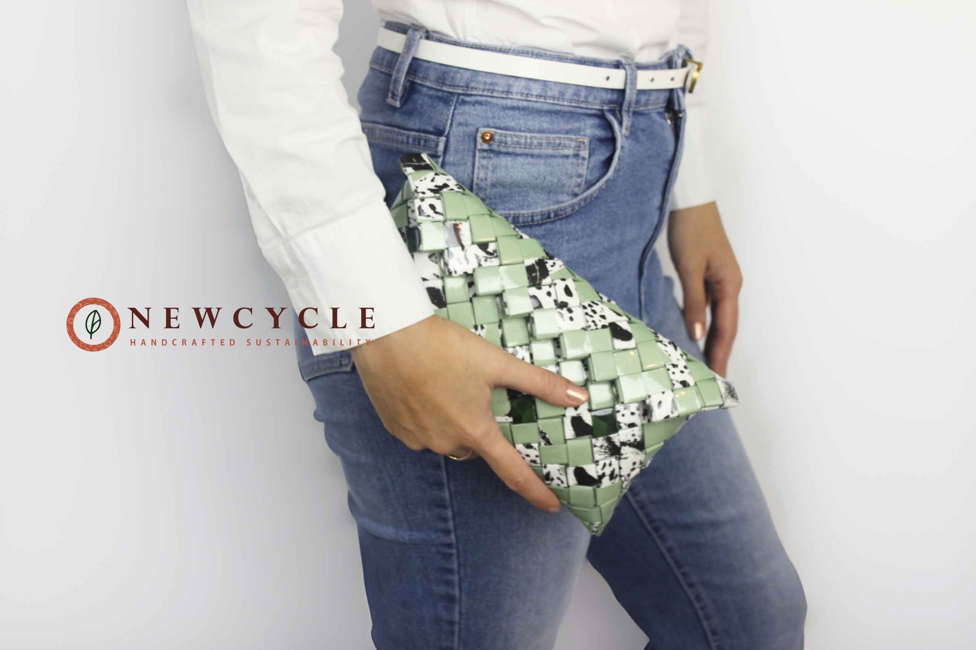 Front view of green woven clutch with black and white animal pattern