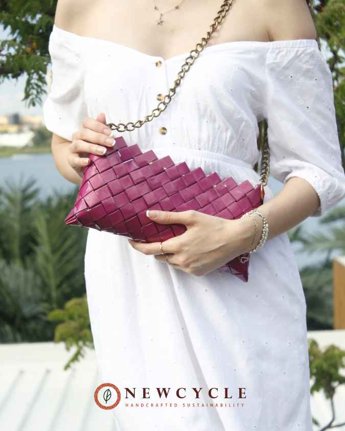 Fuchsia handmade purse held with both hands – upcycled paper weave