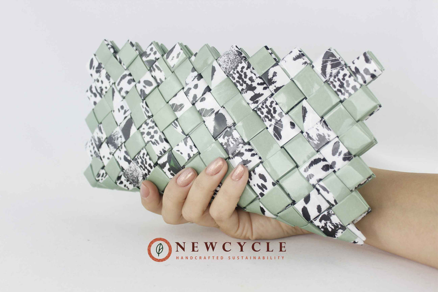 handmade sage green animal print clutch held in hand
