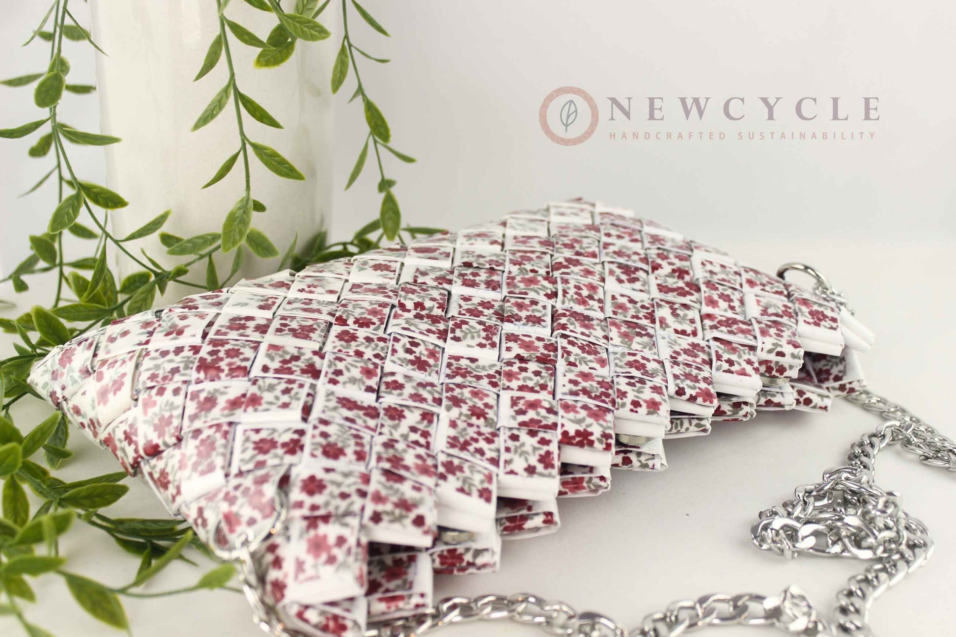 Red floral hand-woven purse displayed with silver chain