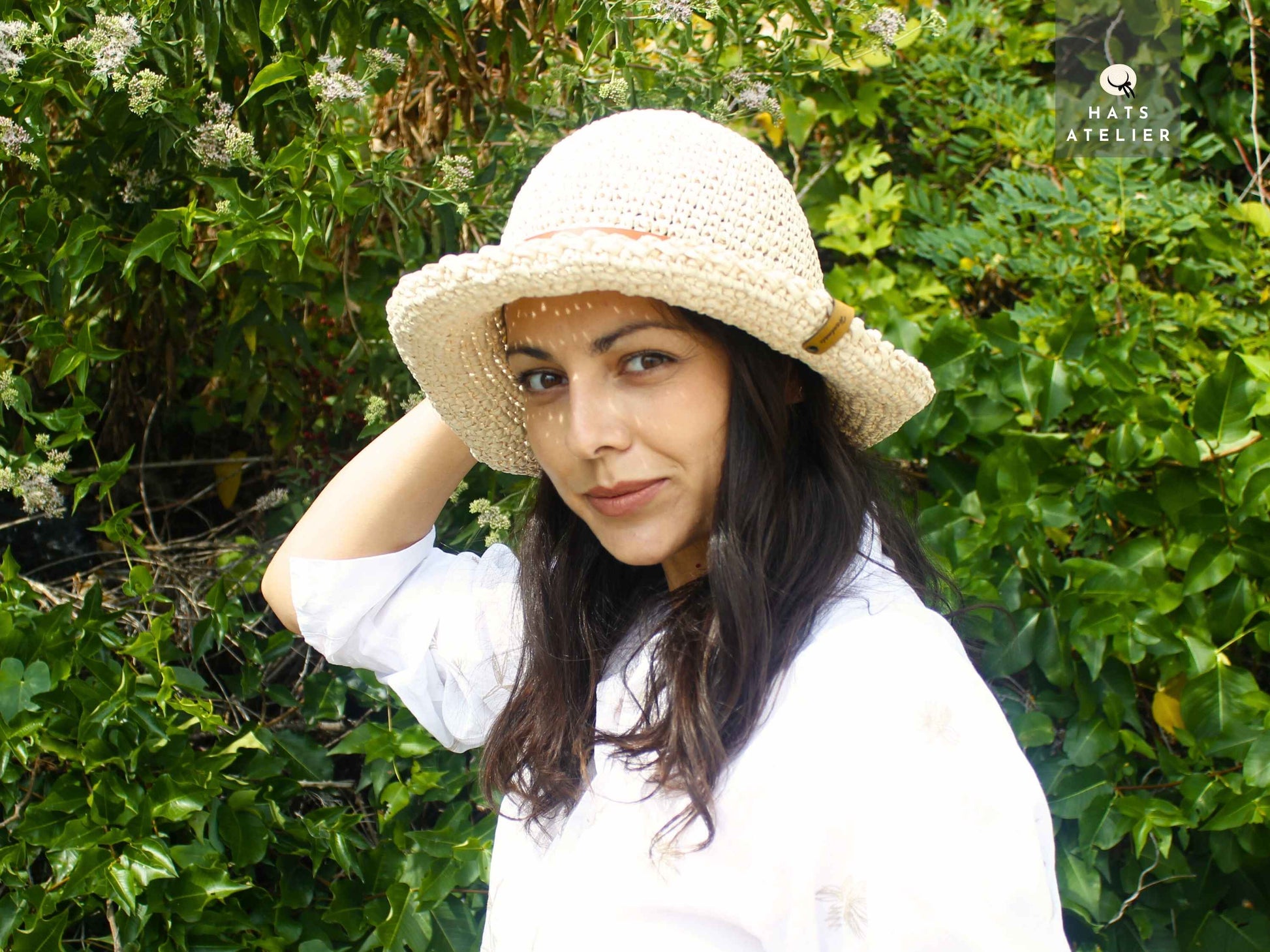 Handwoven natural raffia straw hat with medium brim side view