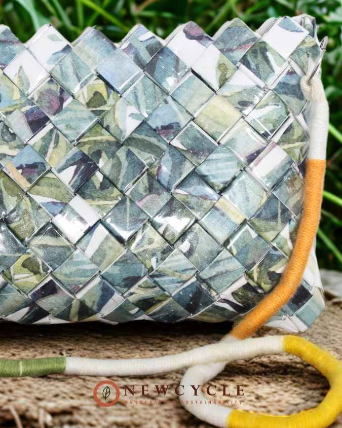 Leaf-pattern woven crossbody bag placed on wooden floor