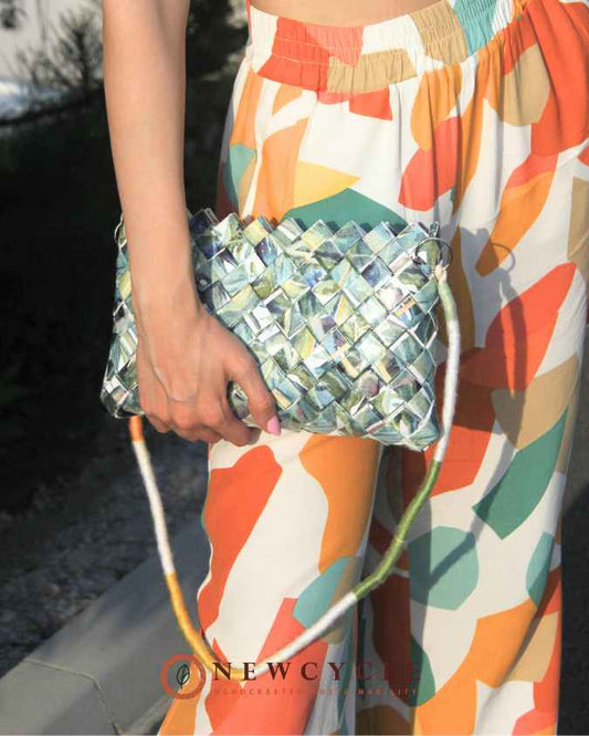 Leaf-pattern woven crossbody bag held in hand outdoors