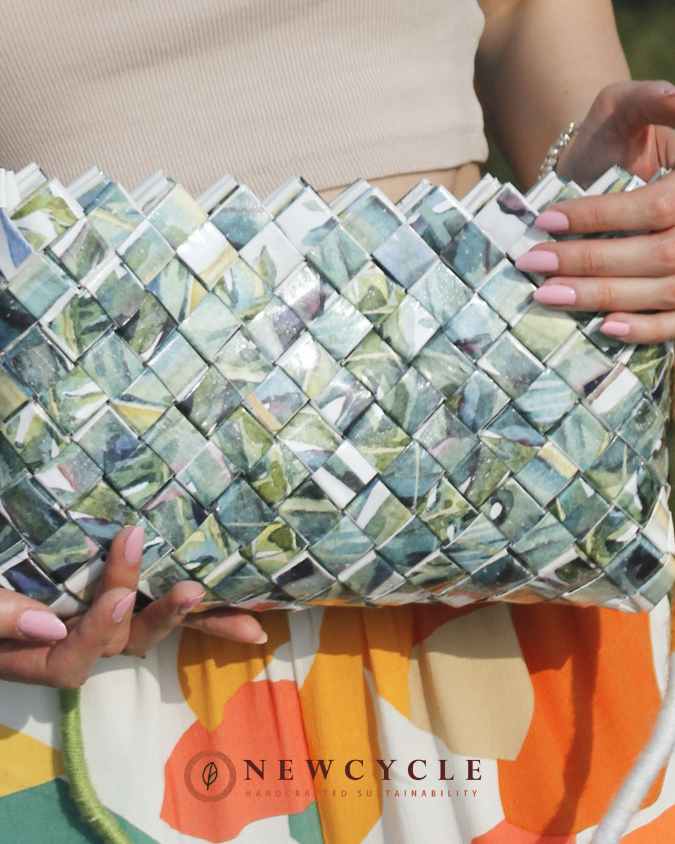 Leaf-pattern handbag held against colorful summer outfit