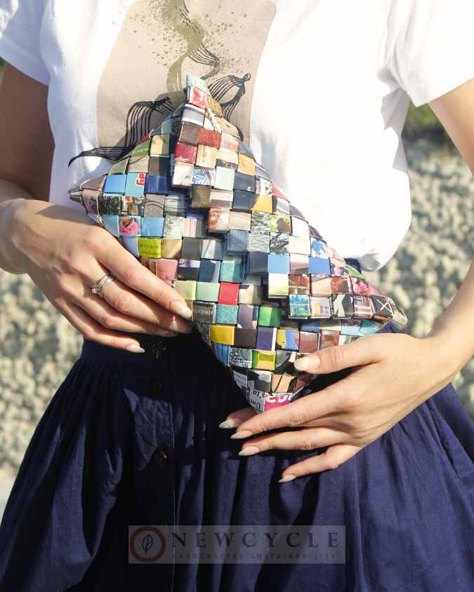 Multicolor eco clutch held close to chest outdoors