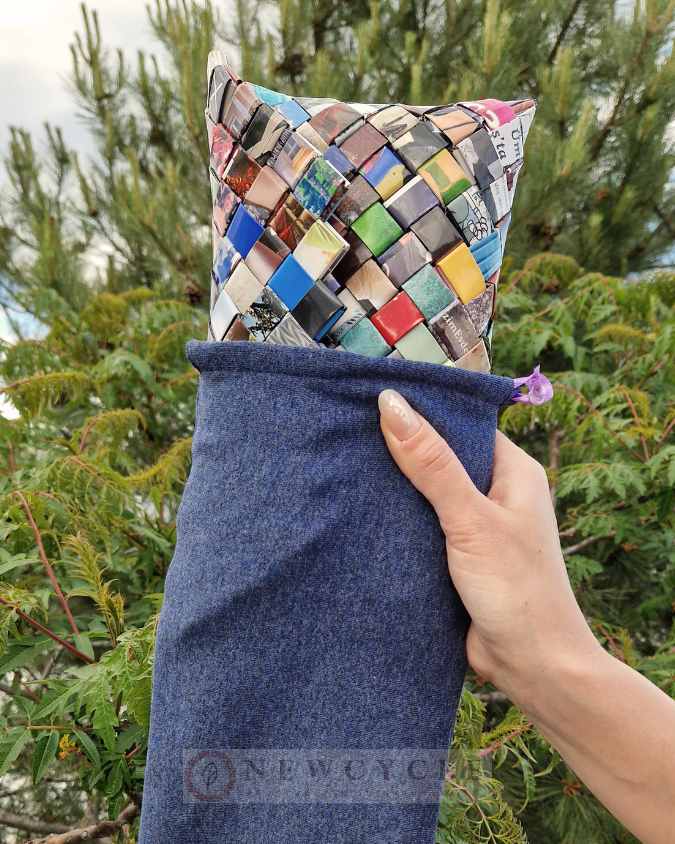 Side view of a multicolor woven clutch held by hand