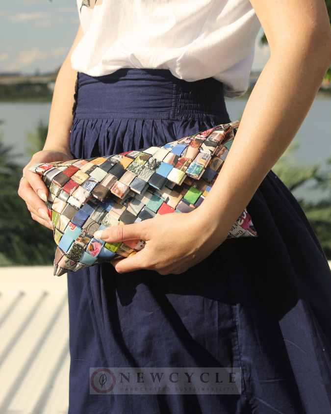 Woman holding a multicolor woven clutch made from upcycled paper strips