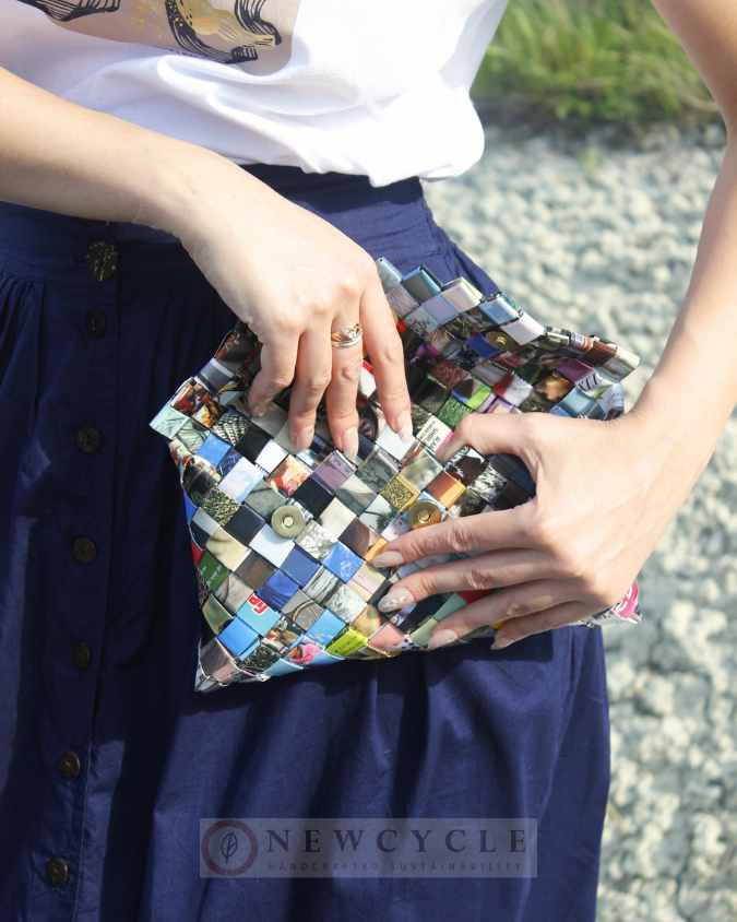 Upcycled multicolor woven purse shown with denim skirt