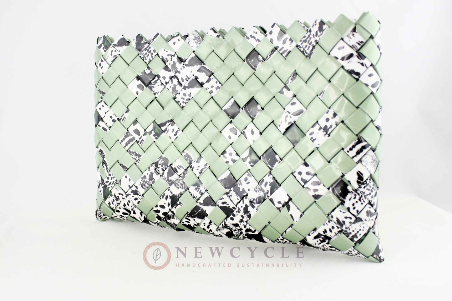 Side view of oversized green hand-woven clutch with animal print details