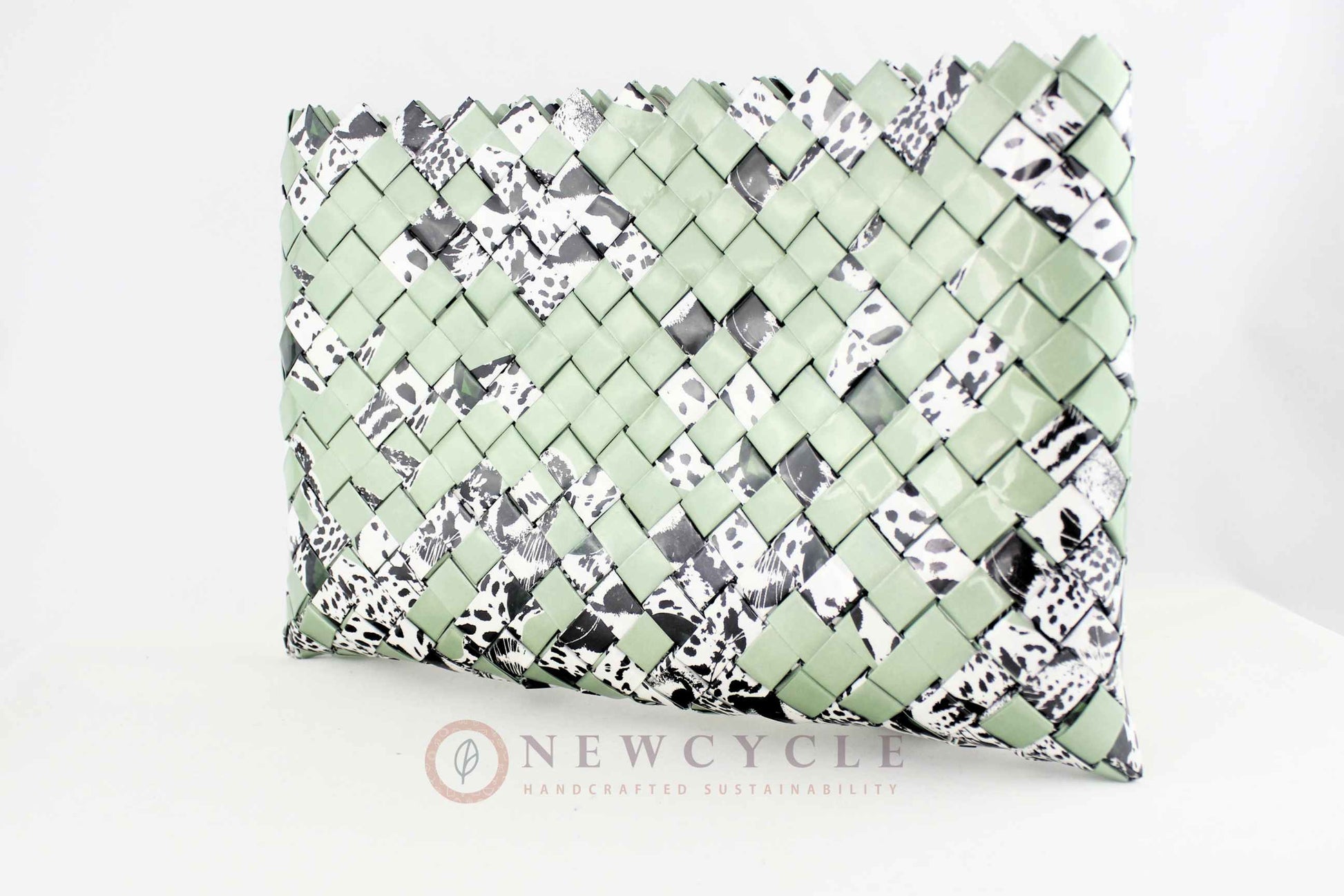 Side view of oversized green hand-woven clutch with animal print details