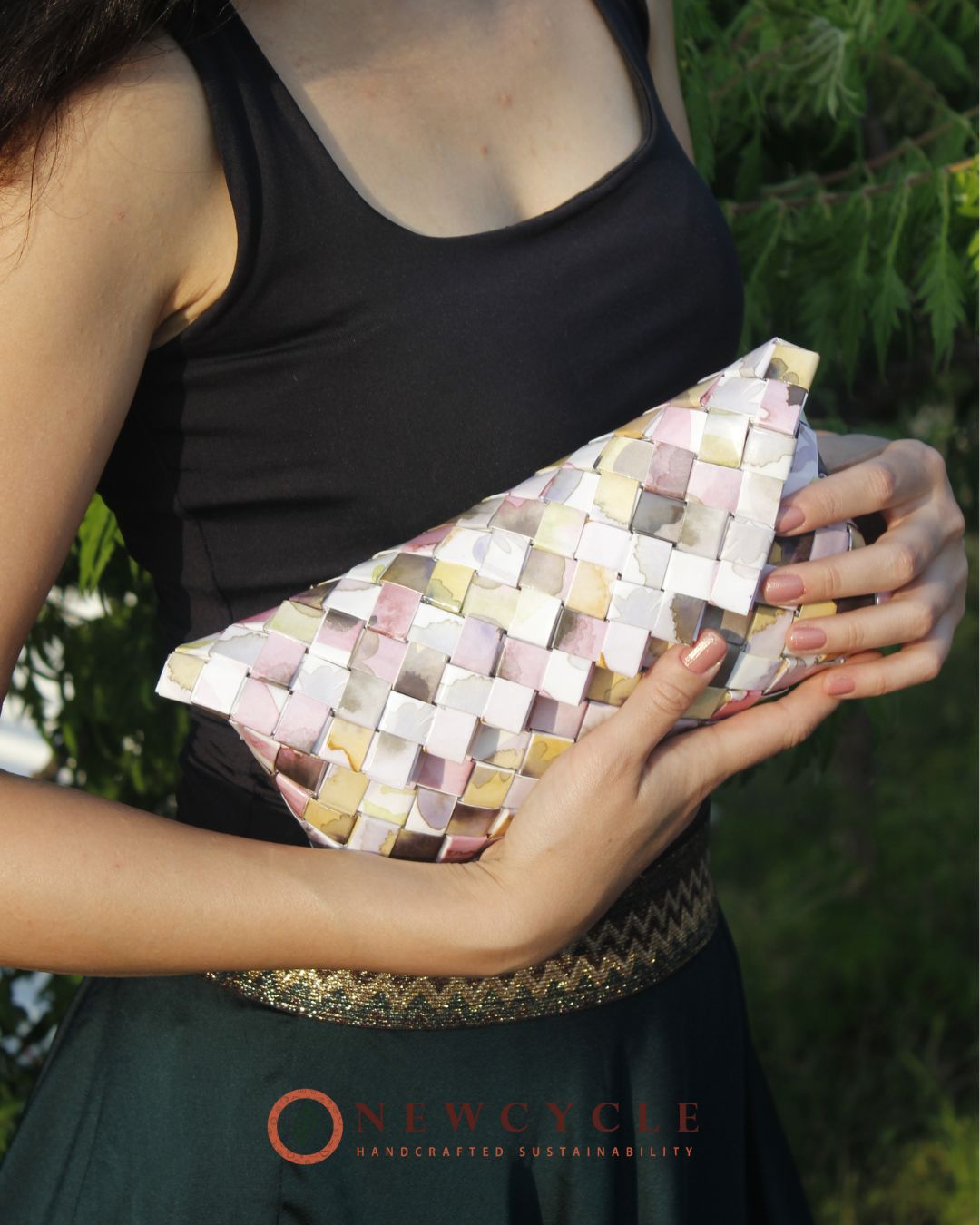 Close-up of pastel pink woven clutch showing handwoven paper texture
