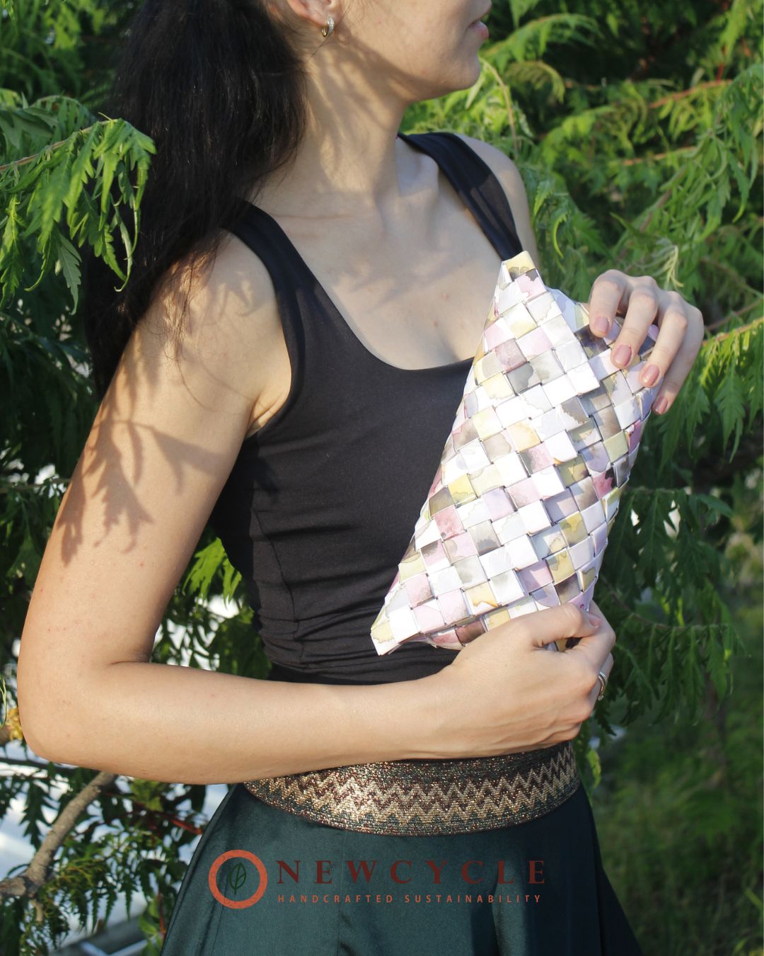Side view of pastel woven clutch with glossy handcrafted finish.