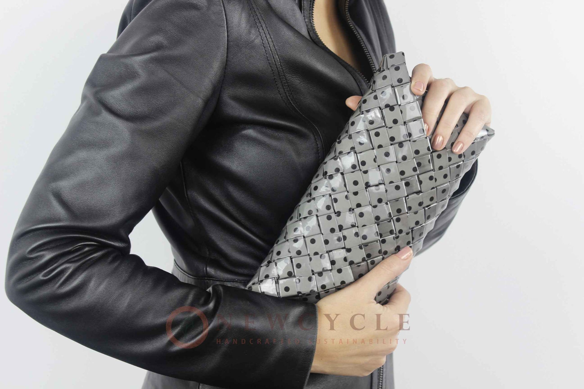 Polka-dot handmade clutch in black and grey worn under the arm