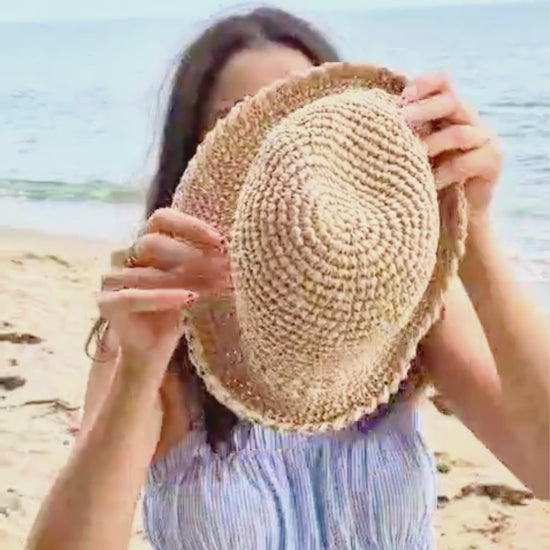 crochet raffia bucket hat worn at the beach as a lightweight summer straw hat