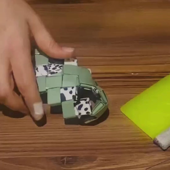 Video showing the hand-woven crafting process of the green oversized clutch with animal print