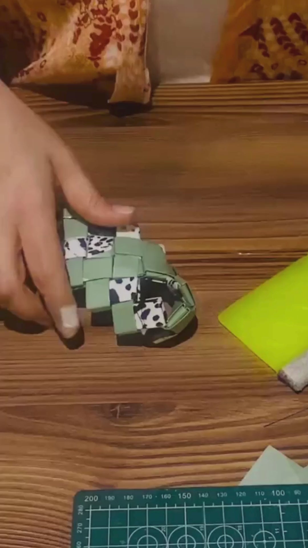 Video showing the hand-woven crafting process of the green oversized clutch with animal print