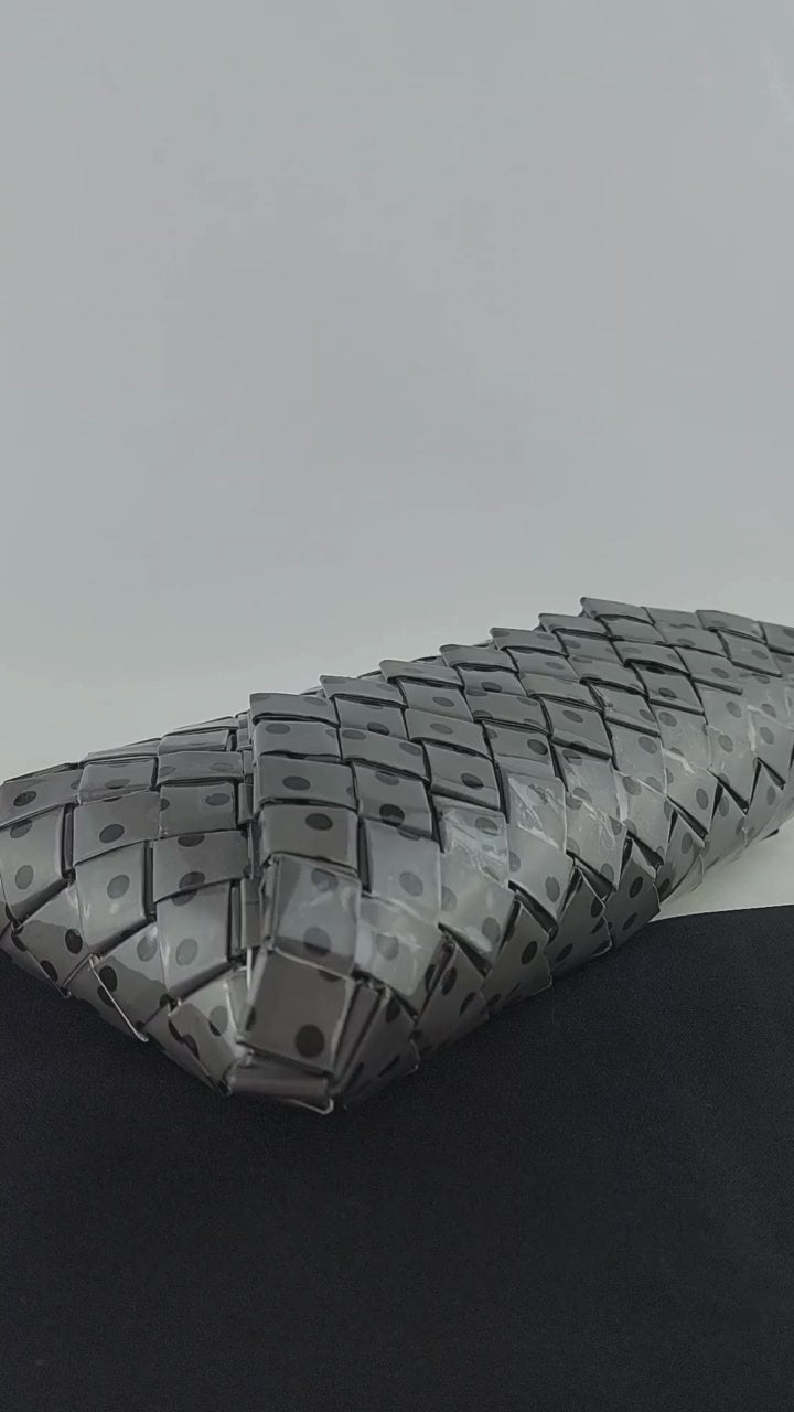Video showing the details of the black and grey polka-dot woven clutch