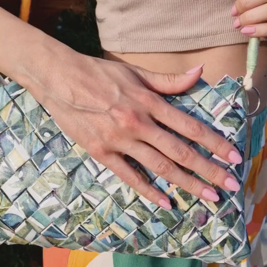 Video showing leaf-pattern woven shoulder bag in natural light