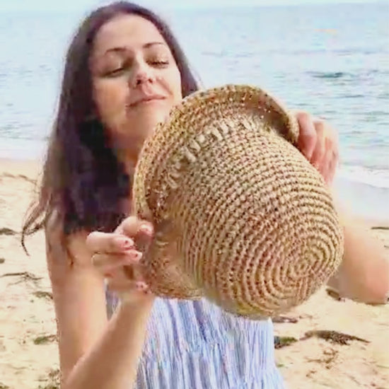Short brim crochet raffia hat in natural straw shown in summer styling video