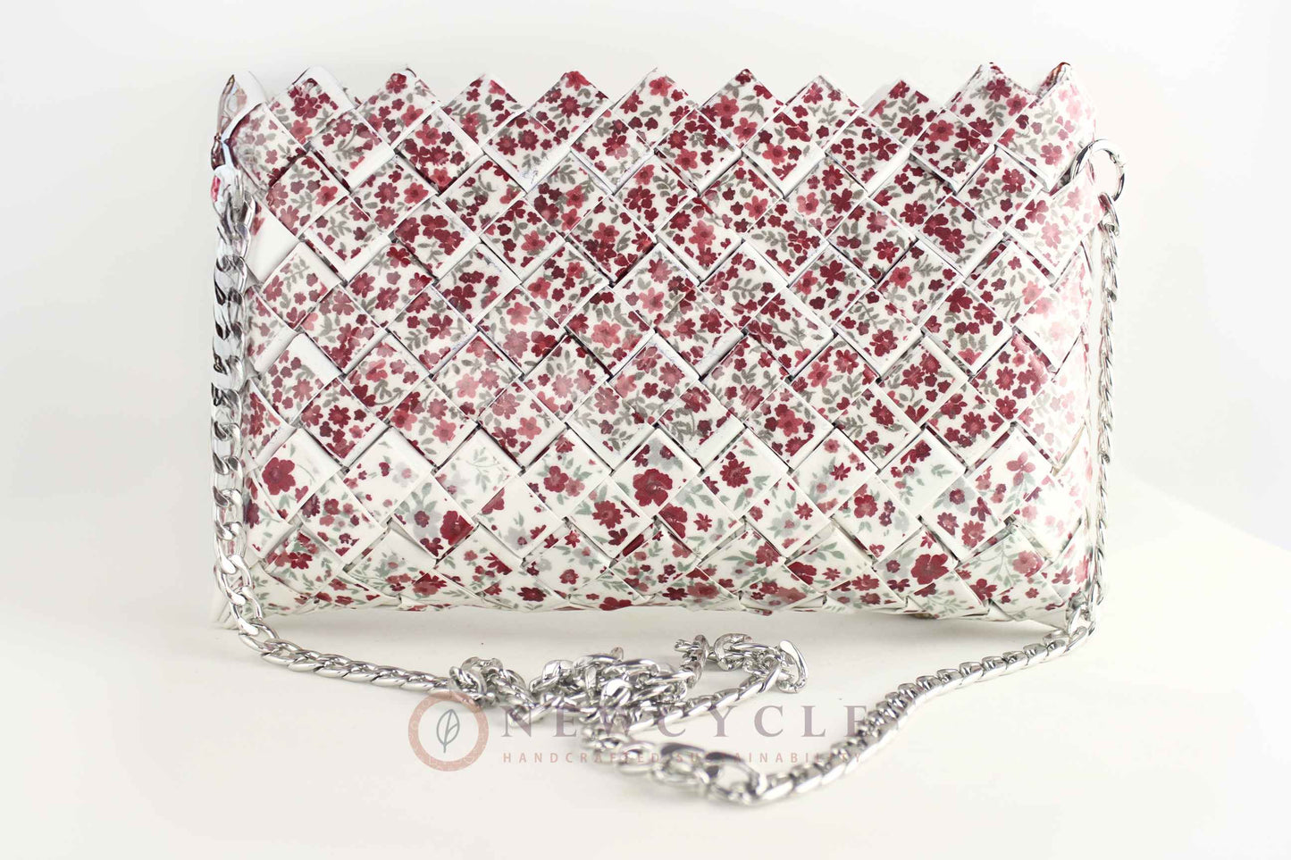 front view of red floral woven purse with silver chain