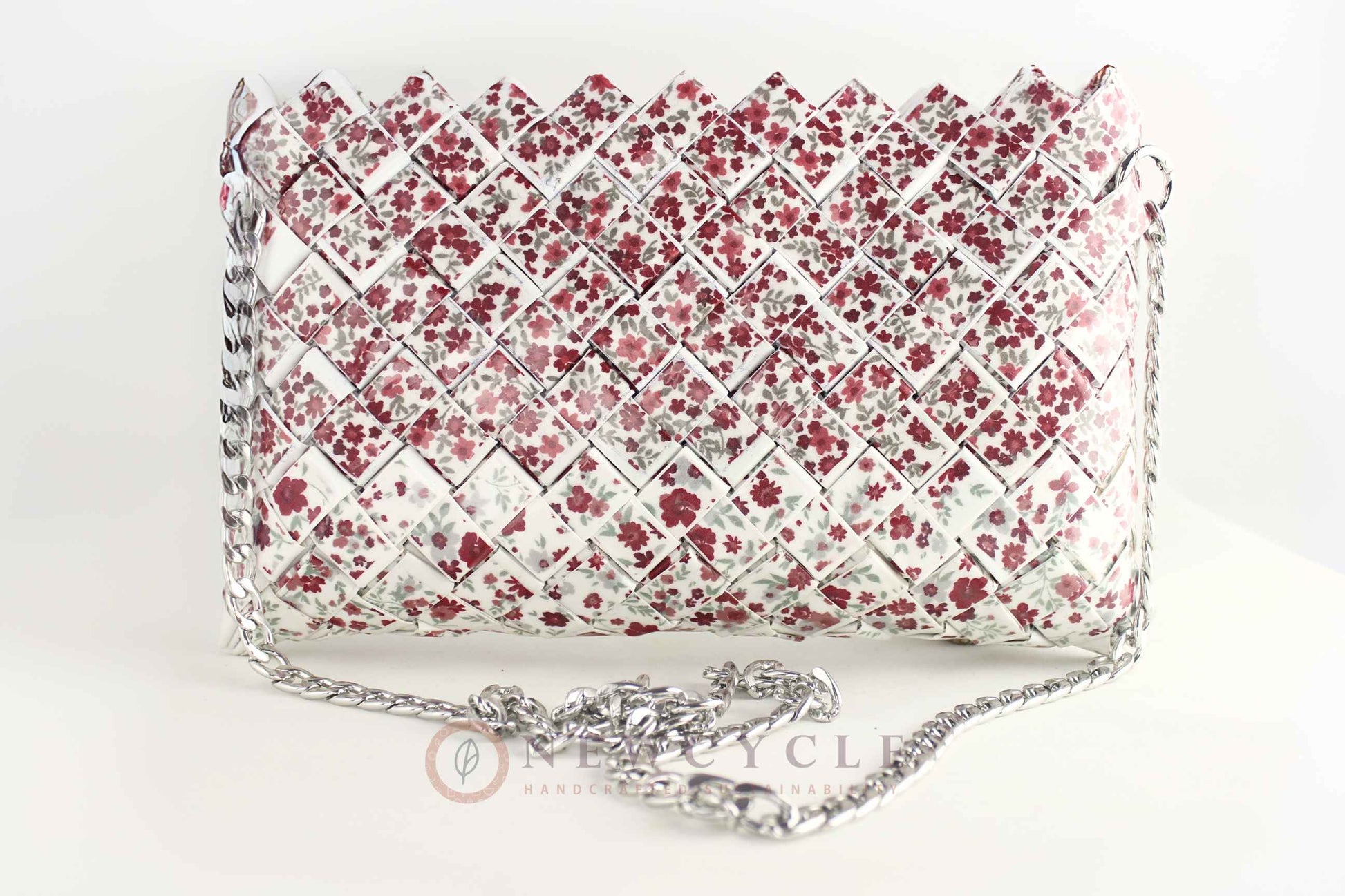 front view of red floral woven purse with silver chain