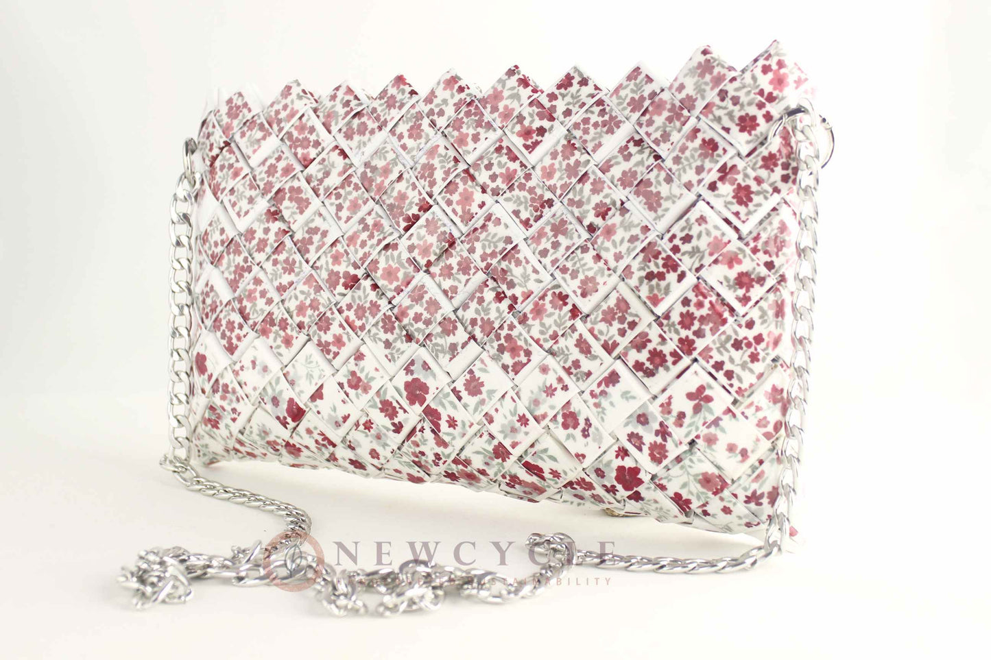 Red floral woven purse with silver chain on white background