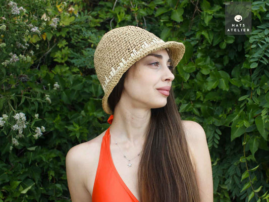 Short brim crochet raffia hat made from natural straw, worn by model in boho summer style