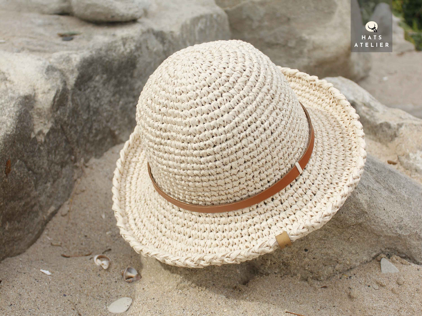 Top view of natural straw crochet raffia hat with medium brim