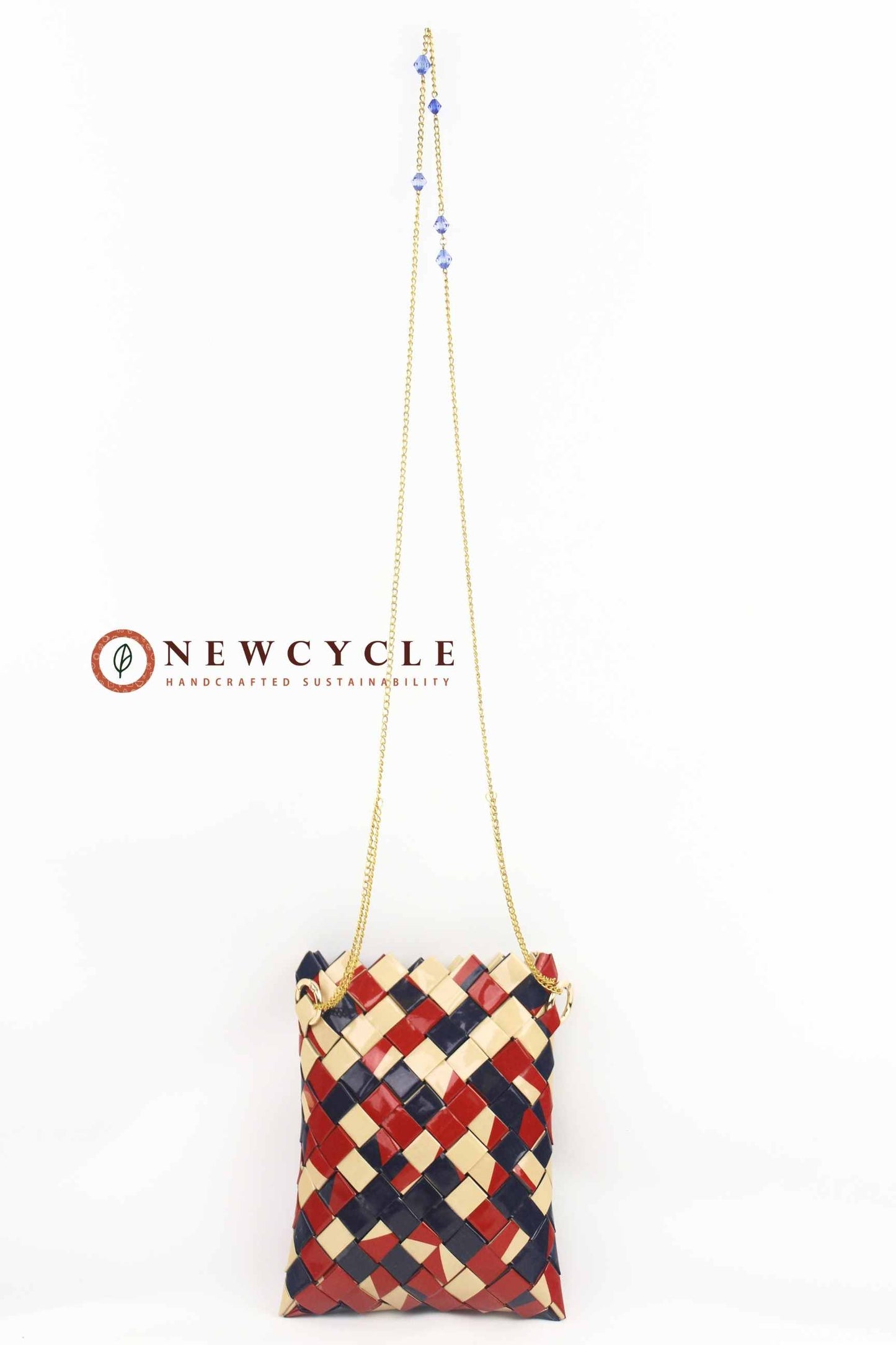Handwoven red navy beige crossbody bag hanging by gold chain strap